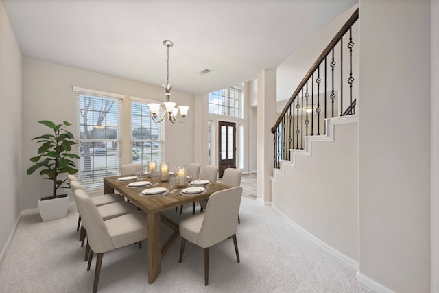 dining space with a chandelier, visible vents, light colored carpet, and baseboards