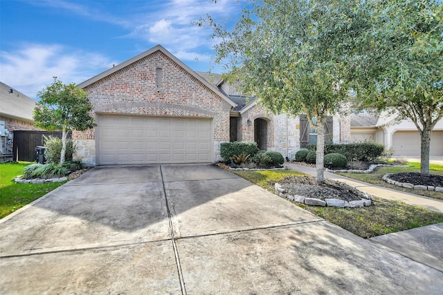 view of front of property featuring a garage, stone siding, brick siding, and concrete driveway