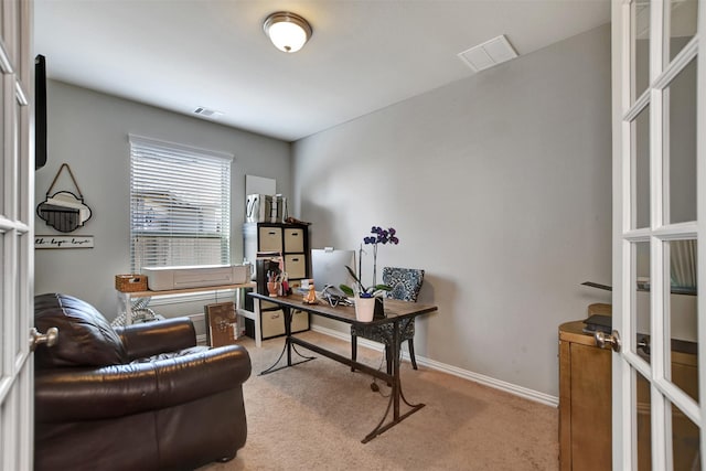 office area with visible vents, light carpet, and baseboards