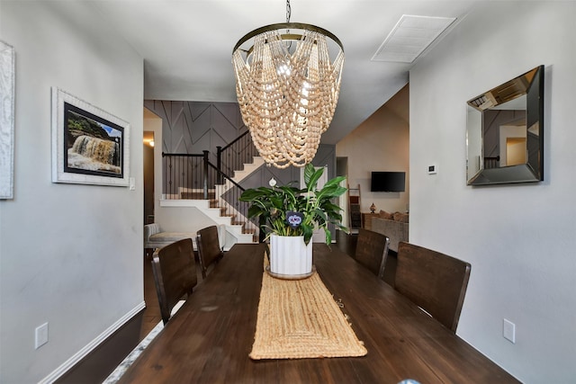 dining space featuring stairway, baseboards, visible vents, and a chandelier