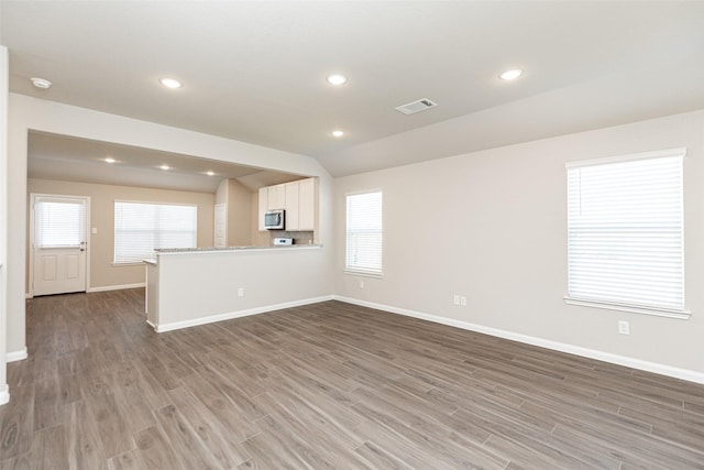 unfurnished living room with light wood-style flooring, recessed lighting, baseboards, and visible vents