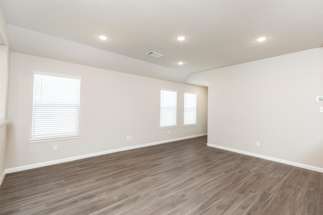 unfurnished room with recessed lighting, wood finished floors, visible vents, and baseboards