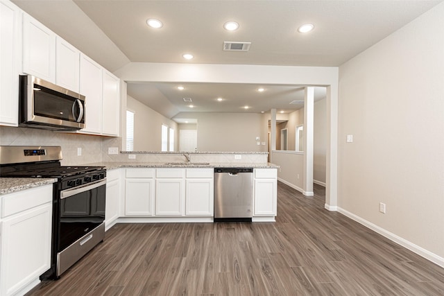 kitchen with visible vents, backsplash, appliances with stainless steel finishes, a peninsula, and white cabinetry