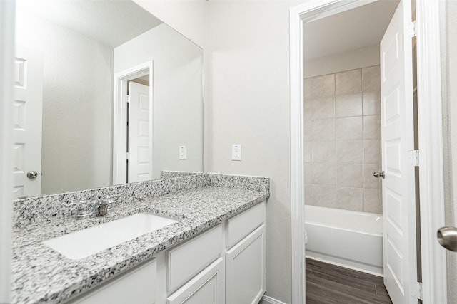 bathroom with toilet, tub / shower combination, vanity, and wood finished floors