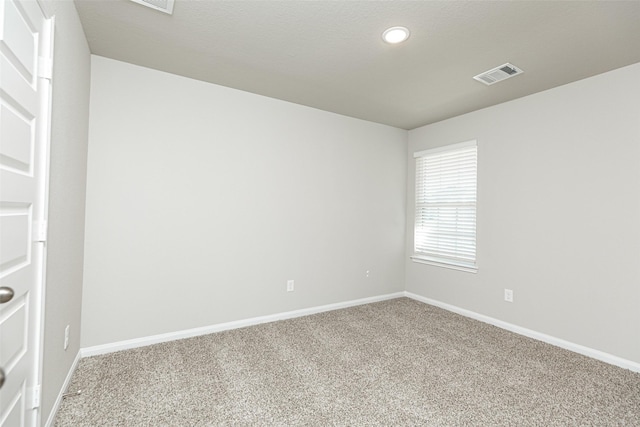 spare room featuring visible vents, carpet floors, and baseboards