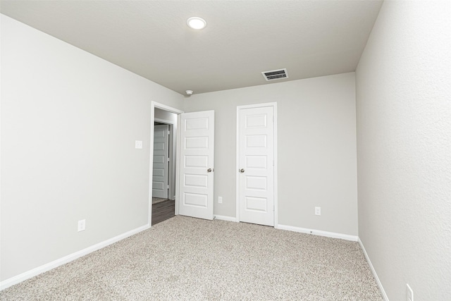 unfurnished bedroom with visible vents, baseboards, and carpet