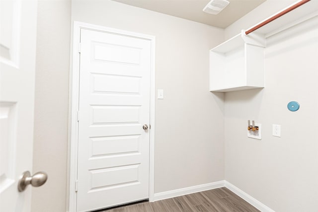 clothes washing area featuring visible vents, washer hookup, wood finished floors, baseboards, and laundry area