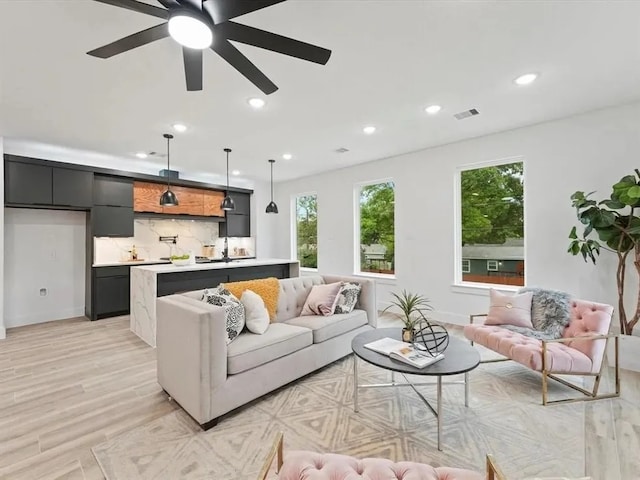 living area featuring recessed lighting, visible vents, a ceiling fan, and light wood finished floors