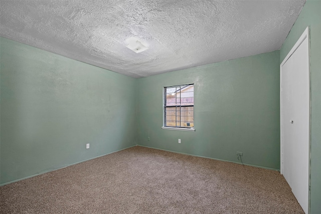 empty room with carpet and a textured ceiling