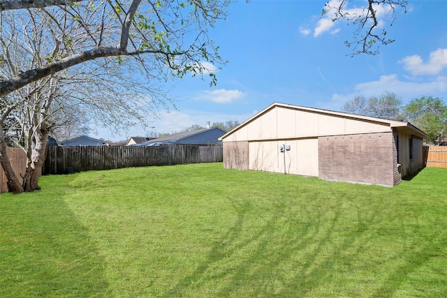 view of yard with an outdoor structure, a fenced backyard, and an outbuilding