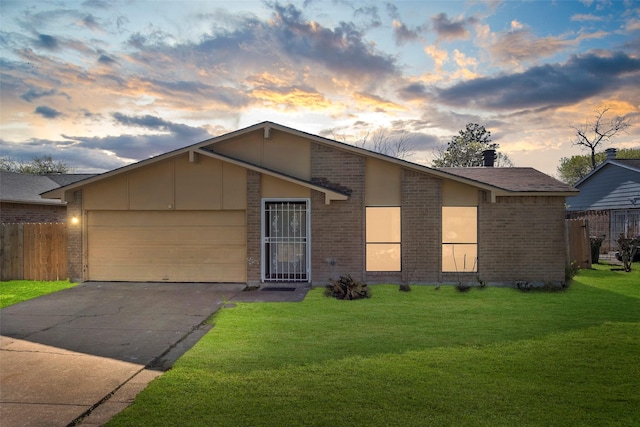 mid-century inspired home with a front lawn, a garage, fence, and brick siding