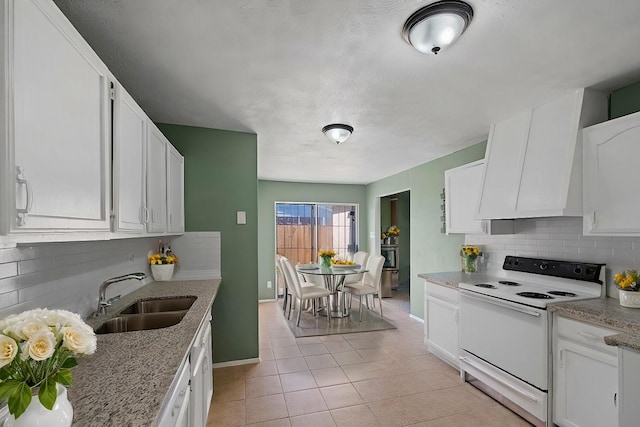 kitchen with backsplash, light tile patterned flooring, white cabinetry, white electric range, and a sink