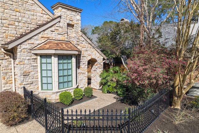 entrance to property with stone siding and fence