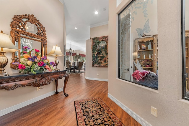 hallway with recessed lighting, ornamental molding, baseboards, and wood finished floors