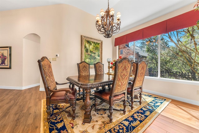 dining room with baseboards, wood-type flooring, and a chandelier