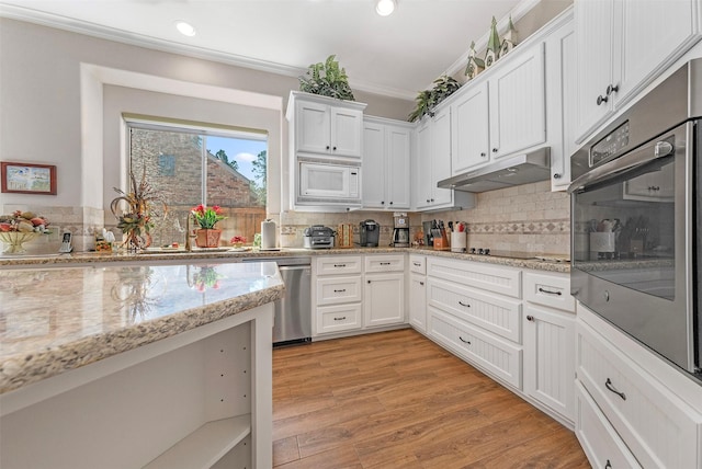 kitchen with white microwave, a sink, under cabinet range hood, stainless steel dishwasher, and crown molding