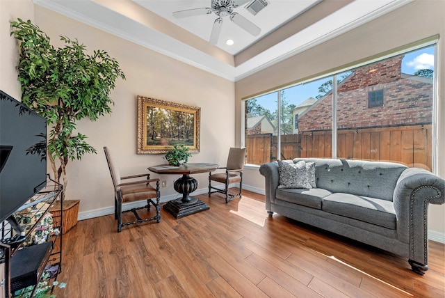 sitting room with a ceiling fan, wood finished floors, visible vents, and baseboards