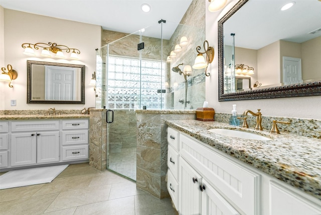 bathroom featuring a sink, two vanities, a shower stall, and tile patterned flooring