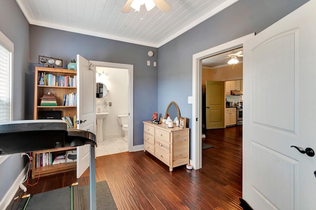 office space with dark wood finished floors, crown molding, a sink, and ceiling fan