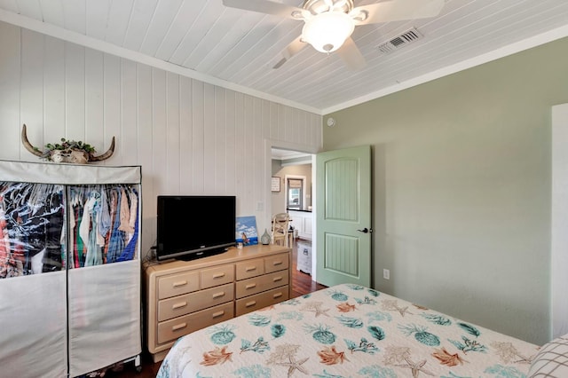 bedroom with visible vents, a ceiling fan, dark wood finished floors, and crown molding