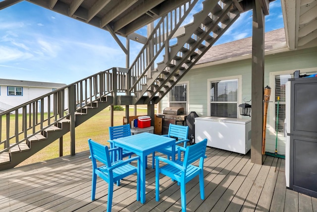 wooden deck featuring outdoor dining area, stairs, a yard, and area for grilling