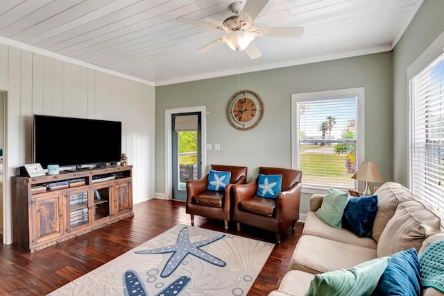 living area featuring ornamental molding, baseboards, ceiling fan, and wood finished floors