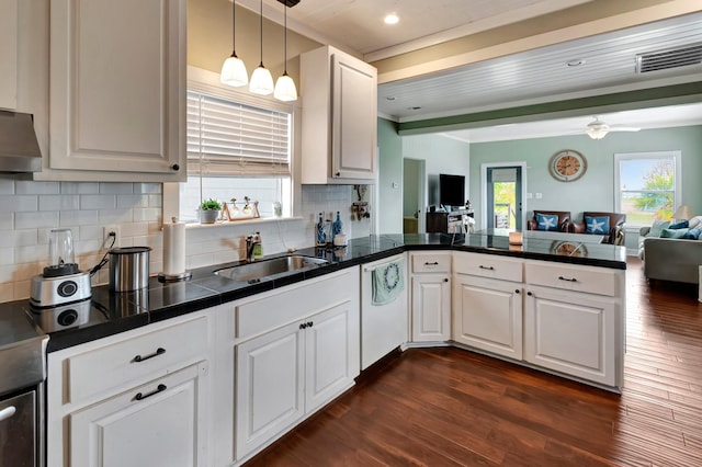 kitchen with a peninsula, dark wood-style flooring, a sink, dishwasher, and open floor plan