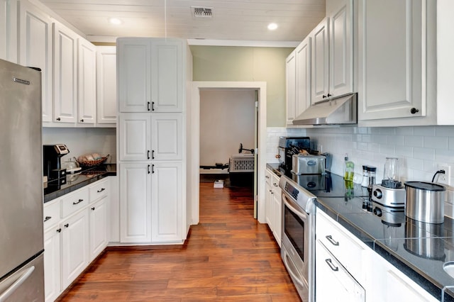 kitchen featuring backsplash, dark wood-type flooring, under cabinet range hood, appliances with stainless steel finishes, and white cabinetry