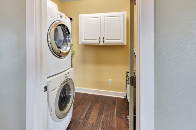 11 Enchanted Ln, Port Alto, TX 77979 - washroom featuring estacked washer and dryer, dark wood-style flooring, and cabinet space