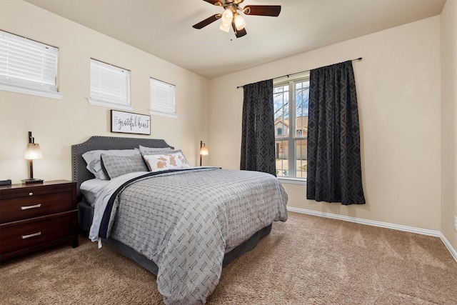 carpeted bedroom with baseboards, multiple windows, and ceiling fan