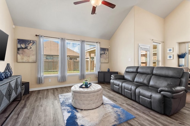 living room featuring high vaulted ceiling, wood finished floors, baseboards, and ceiling fan