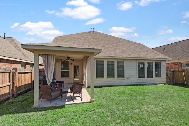 back of property featuring a patio, a ceiling fan, a fenced backyard, a shingled roof, and a lawn