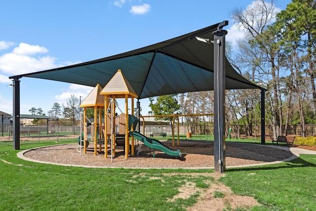 community jungle gym with fence and a lawn