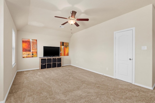 unfurnished living room with vaulted ceiling, a ceiling fan, baseboards, and carpet floors