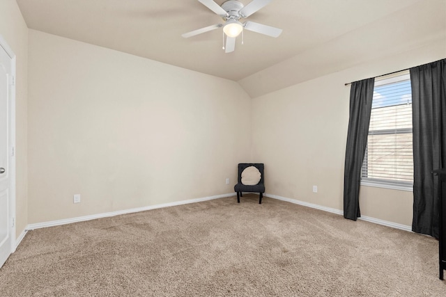 spare room with vaulted ceiling, carpet, baseboards, and ceiling fan