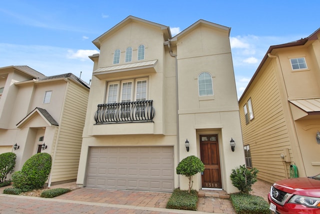 view of property with stucco siding, decorative driveway, and a garage