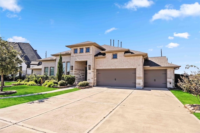 view of front of property with brick siding, an attached garage, concrete driveway, and a front lawn