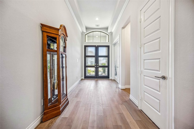 foyer entrance with visible vents, light wood-style flooring, french doors, and baseboards