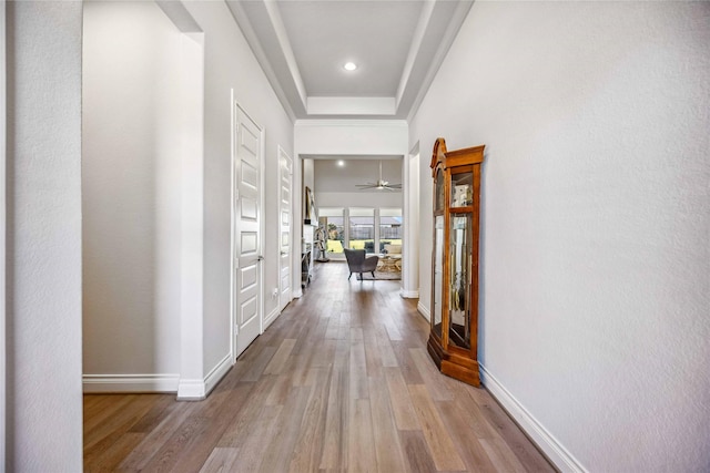 hall featuring light wood-style flooring, recessed lighting, and baseboards