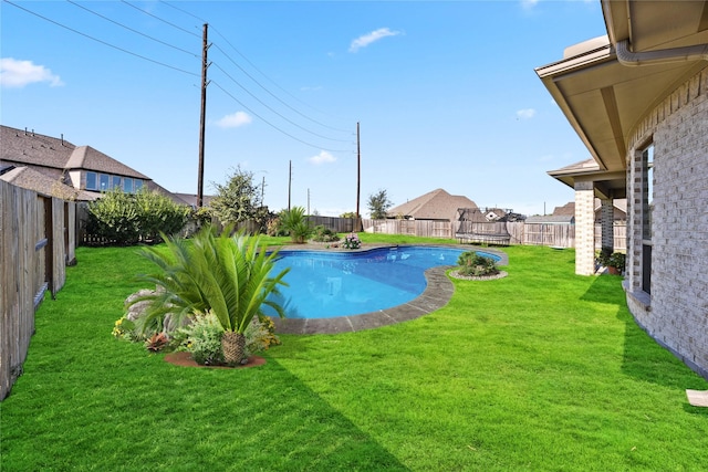 view of swimming pool with a fenced in pool, a fenced backyard, and a lawn