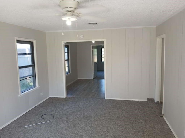 unfurnished room with crown molding, carpet flooring, visible vents, and a textured ceiling