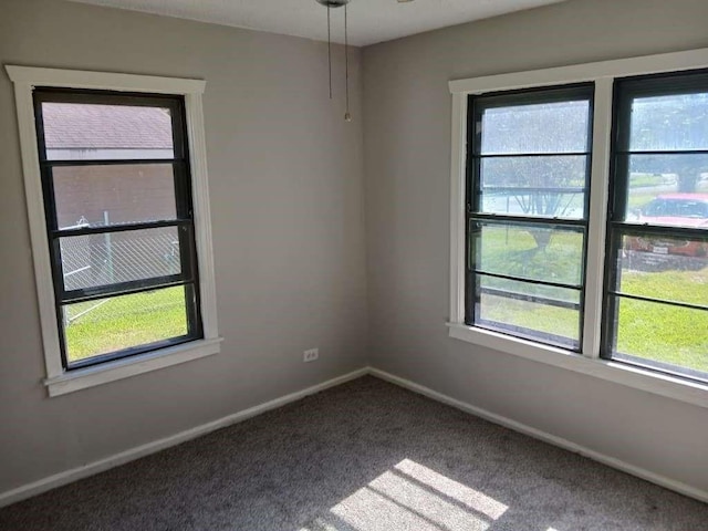 carpeted empty room featuring baseboards