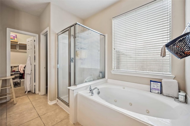 bathroom with a walk in closet, tile patterned floors, a tub with jets, and a shower stall