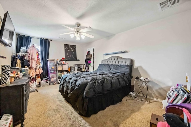 bedroom with visible vents, a textured ceiling, ceiling fan, and carpet flooring