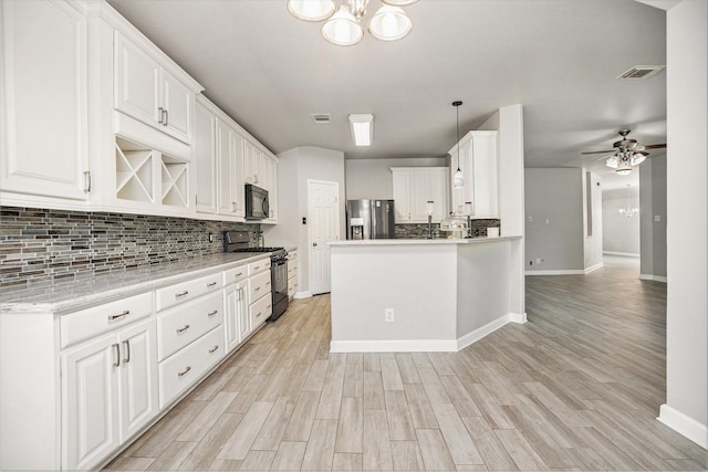 kitchen featuring visible vents, ceiling fan with notable chandelier, gas stove, stainless steel fridge with ice dispenser, and black microwave