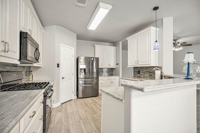 kitchen with visible vents, stainless steel refrigerator with ice dispenser, range with gas cooktop, a peninsula, and black microwave