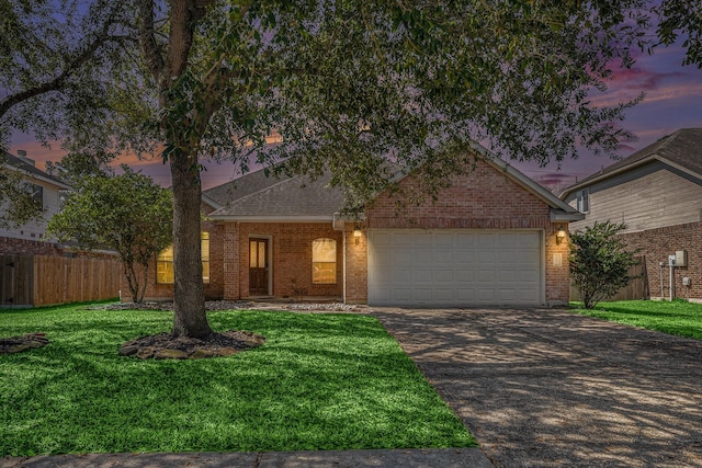 view of front facade featuring fence, brick siding, driveway, and a lawn