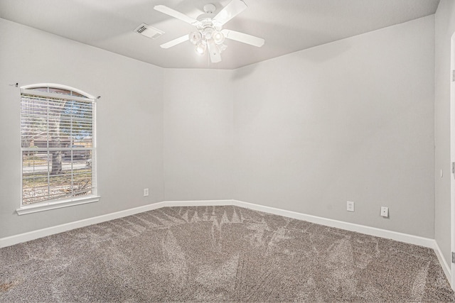 carpeted spare room featuring visible vents, ceiling fan, and baseboards