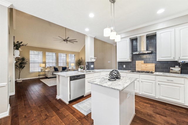 kitchen with dark wood-type flooring, wall chimney range hood, vaulted ceiling, appliances with stainless steel finishes, and a peninsula