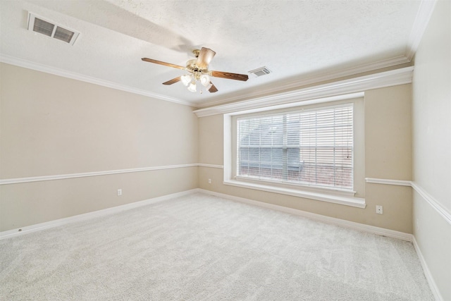 empty room featuring a textured ceiling, carpet, visible vents, and ornamental molding